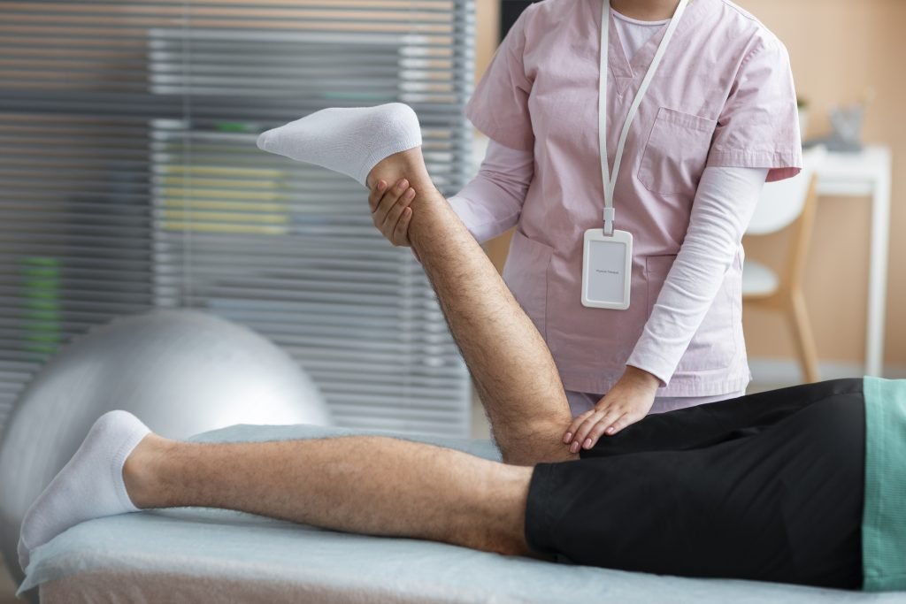 A woman massages a man's leg in a clinical setting at the best orthopedic hospital in Kota.jpeg