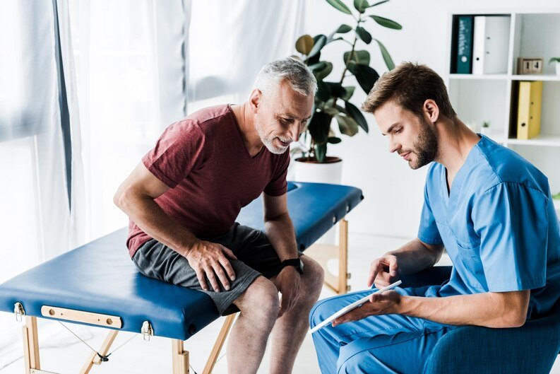 A man sits on a chair with an orthopedic surgeon in Kota, discussing medical concerns.jpeg