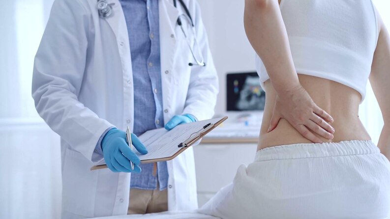 A doctor examines a patient's back in an orthopedic hospital in Kota.jpg