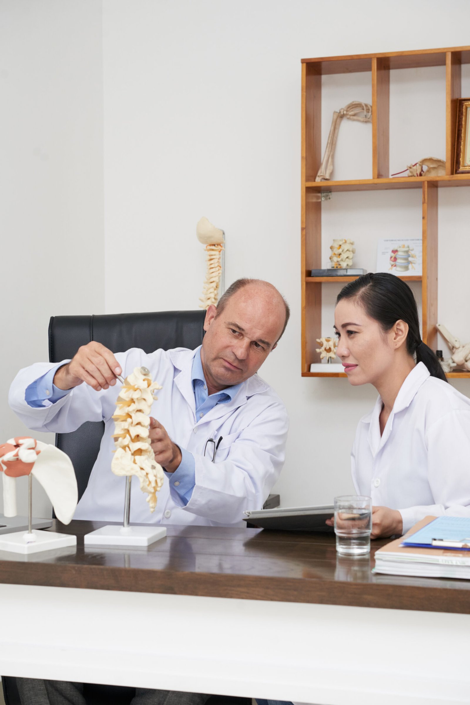 Orthopedics doctor in Kota with physiotherapy team discussing spine treatment using a spine model